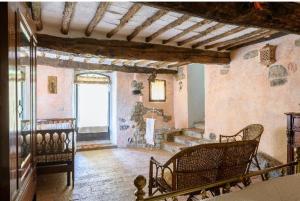 Monte BenichiにあるAntico borgo Il Maceretoのリビングルーム(椅子、大きな窓付)