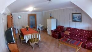 "ハルカーニャ"にあるAbigél Vendégházのリビングルーム(赤いソファ、テーブル付)