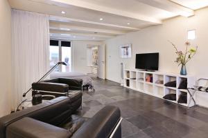 ein Wohnzimmer mit einem Sofa und einem TV in der Unterkunft Luxueuze Studio Herengracht in Amsterdam