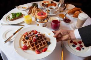 a table with a plate of waffles and fruit on it at Durrants Hotel in London