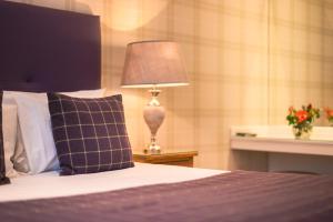 um quarto com uma cama com um candeeiro sobre uma mesa em Braid Apartments by Mansley em Edinburgo