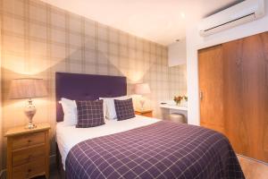 a hotel room with a bed and a dresser at Braid Apartments by Mansley in Edinburgh