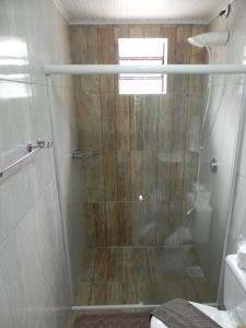 une salle de bain avec une douche avec une porte vitrée dans l'établissement V do Lago Negro, à Gramado