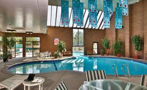 - une piscine dans un hôtel avec une table et des chaises dans l'établissement Coast Wenatchee Center Hotel, à Wenatchee