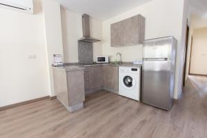 a kitchen with a refrigerator and a washing machine at Apartamentos El Gallo in Marbella