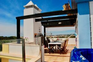 balcón con mesa y faro en Casa na Praia Verde, en Praia Verde