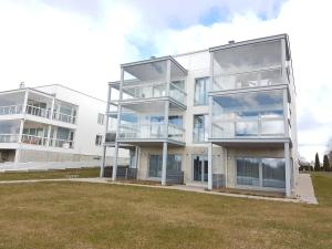 a large white building with balconies and a grass field at Riverstar in Pärnu