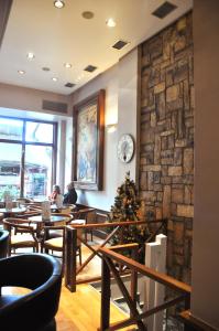 a restaurant with wooden tables and a stone wall at Athens City Hotel in Athens