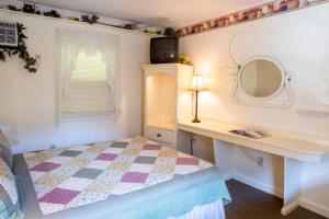 a bedroom with a bed and a desk and a mirror at The Chimney Rock Inn & Cottages in Chimney Rock