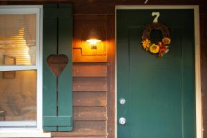 uma porta verde de uma casa com uma coroa de flores em The Chimney Rock Inn & Cottages em Chimney Rock