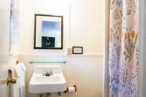 a white bathroom with a sink and a mirror at The Chimney Rock Inn & Cottages in Chimney Rock