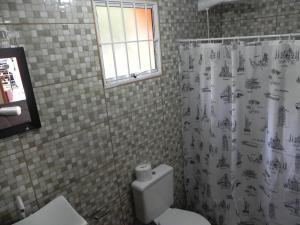 une salle de bain avec toilettes et rideau de douche dans l'établissement V do Lago Negro, à Gramado 35 autres photos