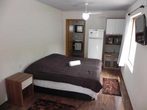 Il comprend une chambre avec un lit et une cuisine équipée d'un réfrigérateur. dans l'établissement V do Lago Negro, à Gramado