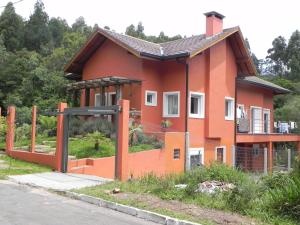 une maison orange avec une porte en face dans l'établissement V do Lago Negro, à Gramado