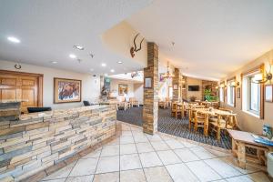 um quarto com um restaurante com mesas e cadeiras em Alpine Inn & Suites Gunnison em Gunnison