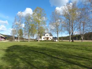 un gran campo con una casa en el fondo en Ferienhaus Björkebo, en Stöllet