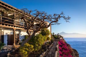 a building with a tree in front of the ocean at Parador de La Gomera in San Sebastián de la Gomera