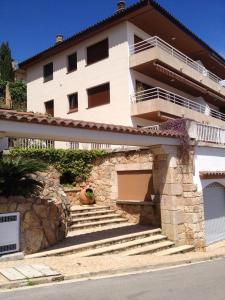 a white house with stairs in front of it at El Mirador de Tossa de Mar in Tossa de Mar