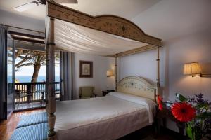 a bedroom with a canopy bed and a balcony at Parador de La Gomera in San Sebastián de la Gomera +37 photos