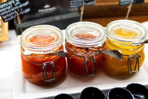 three jars of jam on a tray with spoons in them at Parador de La Gomera in San Sebastián de la Gomera