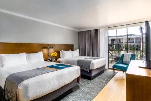 ein Hotelzimmer mit zwei Betten und einem Fernseher in der Unterkunft Town and Country San Diego in San Diego