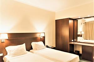 ein Hotelzimmer mit zwei Betten und einem Schreibtisch in der Unterkunft Amazonia Jamor Hotel in Linda-a-Pastora