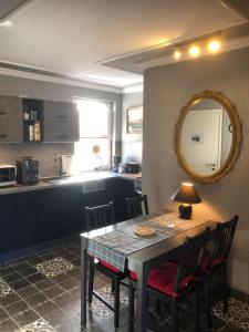 eine Küche mit einem Tisch, Stühlen und einem Spiegel in der Unterkunft Ferienwohnung Schwede in Surendorf