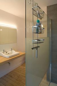 a bathroom with a sink and a glass shower door at Antwerp B&B in Antwerp