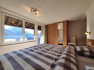 a bedroom with a bed and a large window at Atlantic 1 in Saas-Fee