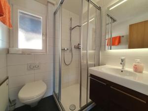 a bathroom with a shower and a toilet and a sink at Atlantic 1 in Saas-Fee