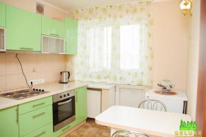 a kitchen with green cabinets and a window at Героев Днепра 53, рядом пляж in Cherkasy