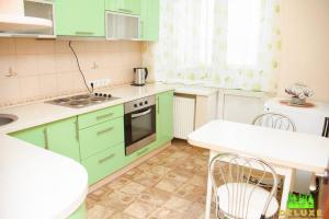 a kitchen with green cabinets and a table and chairs at Героев Днепра 53, рядом пляж in Cherkasy