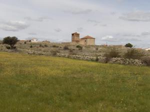um campo com um edifício no topo de uma colina em Casa rural La Senderilla em Ávila