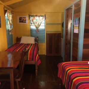 a room with two beds and a table at Colinda Cabanas in Caye Caulker