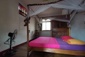 a bedroom with a wooden bed with a canopy at Hotel St-Antoine in Antananarivo