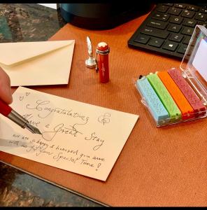 eine Person, die ein Stück Papier auf einem Schreibtisch signiert in der Unterkunft Hotel Mimosa in New York
