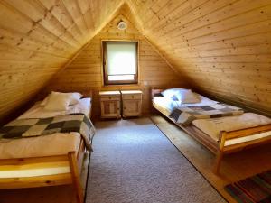 a bedroom with two beds in a log cabin at Pod lipą in Ruciane-Nida