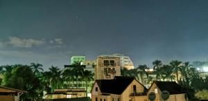 a city at night with buildings and palm trees at Hotel St-Antoine in Antananarivo