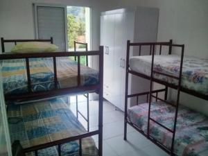 two bunk beds in a room with a window at Apartamento de 2 quartos em maresias com piscina in Maresias +42 photos