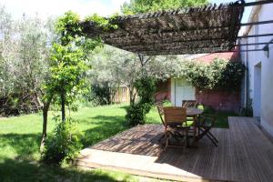 a patio with a table and chairs on a wooden deck at Les Airis in Avignon