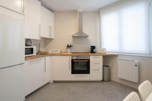 kuchnia z białymi szafkami i kuchenką w obiekcie Bilbao High Apartment w mieście Bilbao