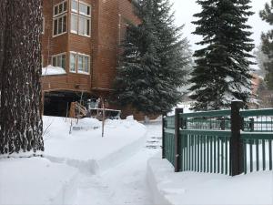 a house with a green fence in the snow at Mountainback #71 in Mammoth Lakes