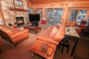 a living room with leather furniture and a stone fireplace at Mountainback #52, Loft, Corner in Mammoth Lakes