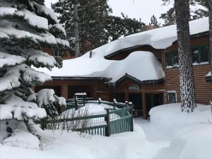 a log cabin with snow on the roof at Mountainback #72, Corner Unit in Mammoth Lakes