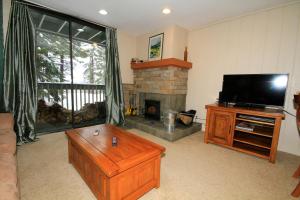 a living room with a television and a fireplace at Crestview #63 in Mammoth Lakes