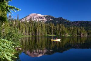 two people in a boat on a lake with a mountain at Crestview #63 in Mammoth Lakes