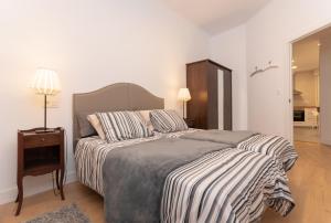 sypialnia z dużym łóżkiem z prześcieradłem w obiekcie Bilbao High Apartment w mieście Bilbao