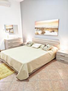 カステッランマーレ・デル・ゴルフォにあるCasa vacanza Nicuzzaの大きなベッド付きのベッドルーム1室、壁に絵画が飾られています。