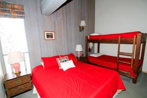 a bedroom with two beds with red sheets at Mammoth Ski & Racquet Club #074 in Mammoth Lakes
