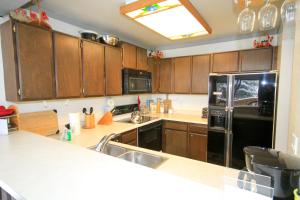 a kitchen with wooden cabinets and a black refrigerator at Mammoth Ski & Racquet Club #074 in Mammoth Lakes